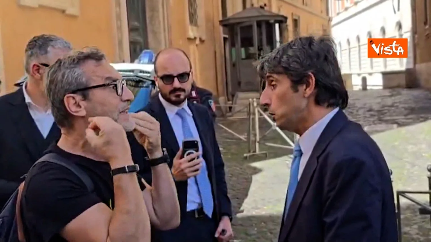 Donzelli é confrontado fora de Montecitorio durante entrevista sobre imigração; debate com manifestante da Libera
