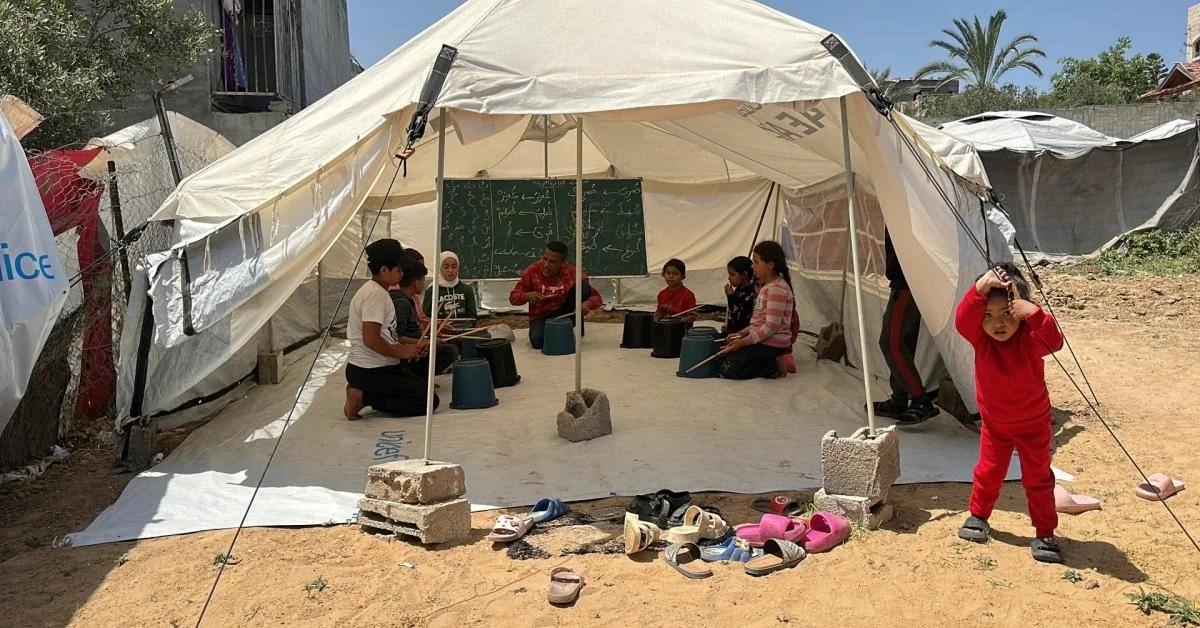 Gaza: crianças deslocadas transformam baldes e bastões em música para sobreviver ao trauma